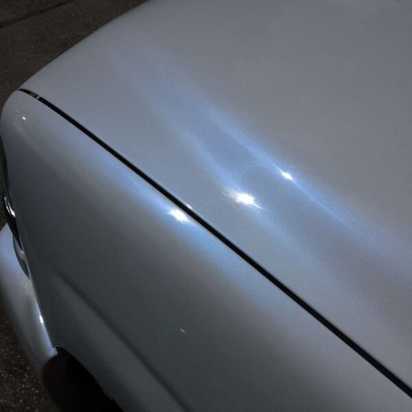 Close up of a white truck with blue spectre pearl