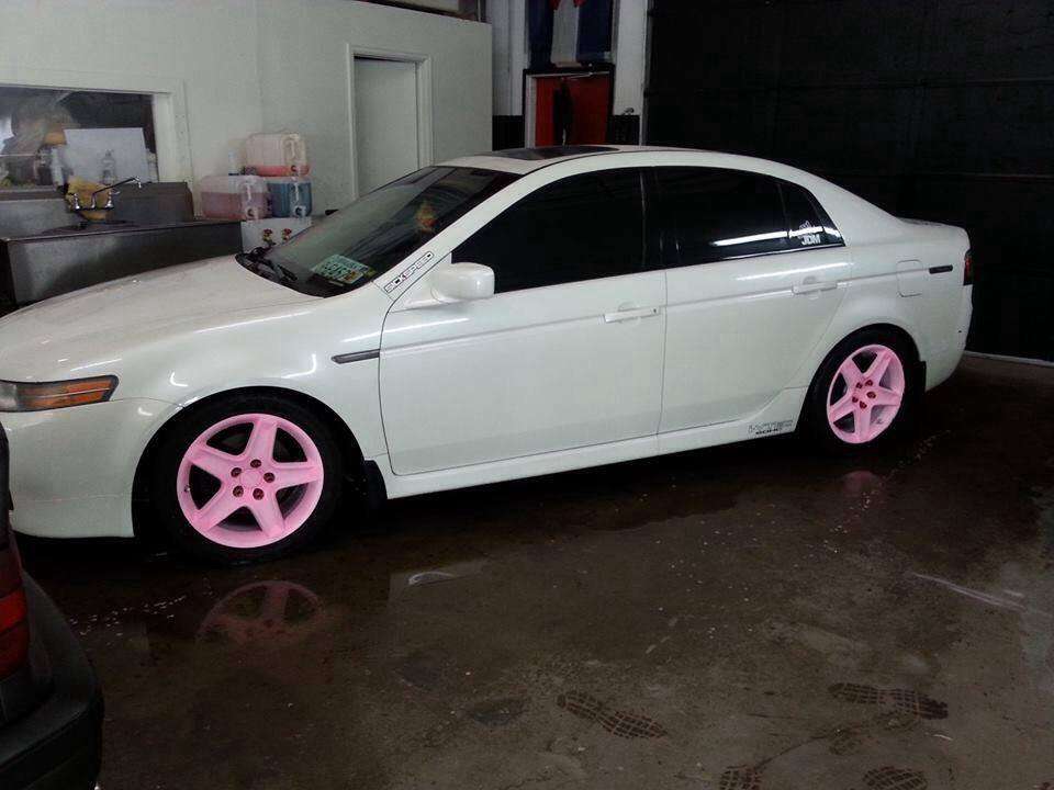 Car with the pink to orange glow in the dark wheels in the light.
